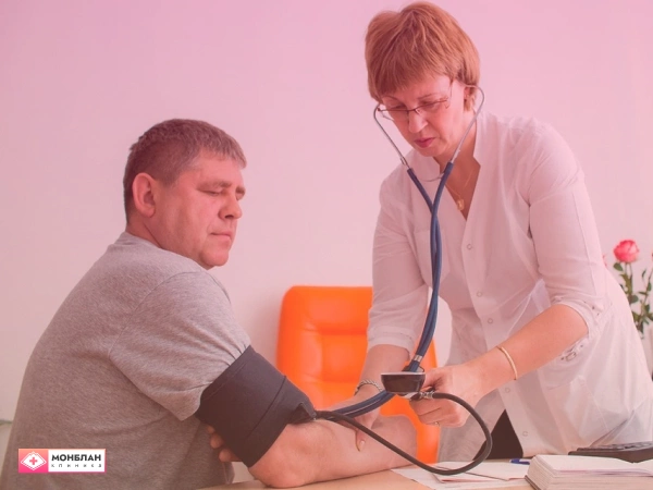 Врач измеряет давление мужчине перед снятием алкогольной интоксикации